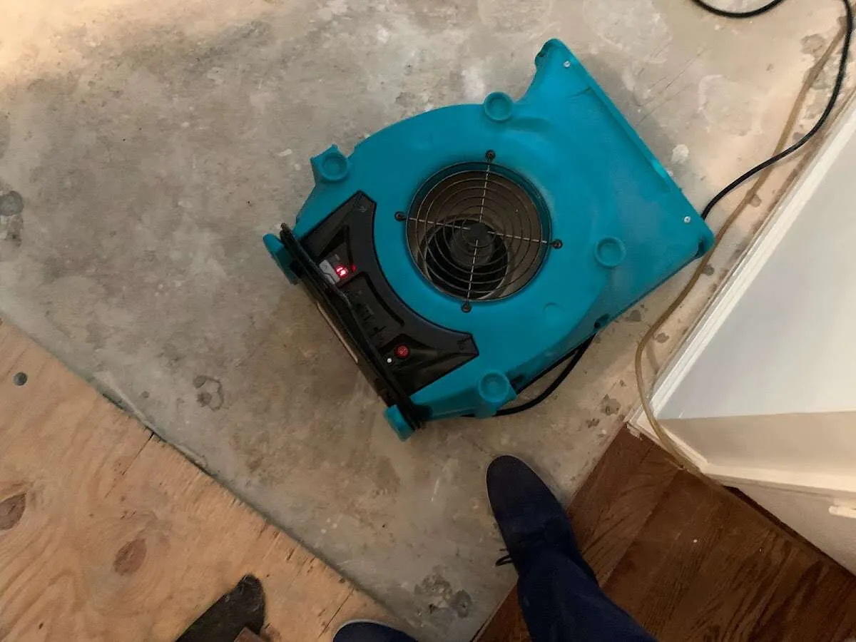 Air mover drying subfloor during Commercial Water Damage Restoration in Winona Lake
